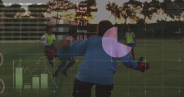 Kaleci takım arkadaşları top sürerken, turta ve bar kaplamalarını spor teknolojisiyle gösterirken onları koruyor. Sporcular, takım çalışması, rekabet, açık hava, spor, strateji, canlı