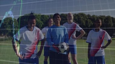 Kadın futbol takımı çimen sahasında yan yana duruyor. Finans şamdanları üst üste biniyor. Sporcular, takım çalışması, fitness, açık hava, dinamik, motivasyon, rekabetçi