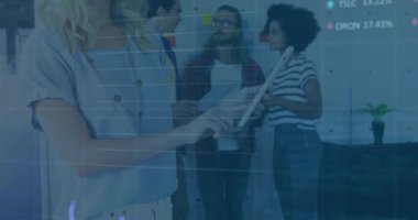 Meslektaşları teknoloji ofisinde iş birliği yaparken kadın tableti tıklatıyor, dijital grafikler masa örtüyor. İşbirliği, takım çalışması, modernlik, yenilik, üretkenlik, iş dünyası, dijital