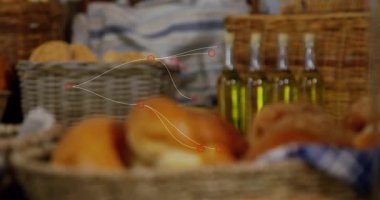 Mavi ve beyaz kareli kumaş üzerinde duran çeşitli altın ekmek ruloları tutan hasır sepet. Fırın, köy, zanaat, yemek sunumu, konfor, eğlence, geleneksel