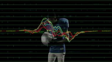 Erkek futbolcu kaskını spor teknikleri demosunda ayarlıyor, neon şebekesi ve dalga formu grafikleri gösteriyor. Sporcu, spor, fütürizm, dijital, performans, analitik, yenilik