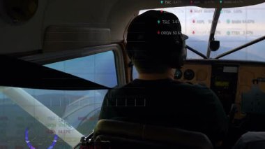 Pilotun kulaklık takması, kokpit izleme göstergelerini izlemesi ve finans grafiklerini saatlerle göstermesi. Uzay, havacılık, gösterge paneli, grafik, analitik, teknoloji, şirket