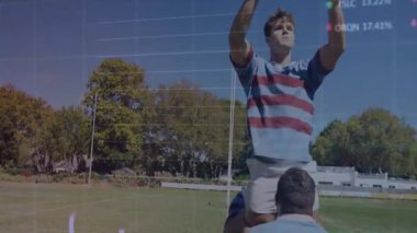Erkek rugby oyuncusu çimenli sahada takım arkadaşları tarafından kaldırılıyor ve spor analizi çizelgeleri gösteriliyor. Atletizm, takım çalışması, rekabet, açık hava, enerji, hareket, stratejik