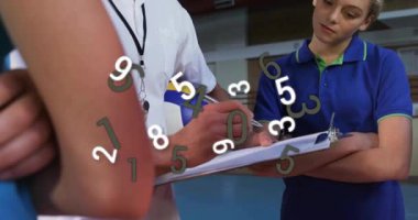 Koç, spor salonundaki atlet performansını gözden geçiriyor. Eğitim verilerini yüzen numaralarla gösteriyor. Spor, eğitim, akıl hocalığı, eğitim, fitness, takım çalışması, dinamik