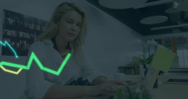 Yetişkin bir kadın masasında oturuyor, iş teknolojisi çalışma alanındaki neon yeşil grafik örtüleriyle etkileşimde bulunuyor. Profesyonel, modern, enerjik, yaratıcı, işbirlikçi, yenilikçi, dijital