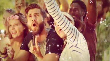 Yeşil parkta, pazarlama parçacıkları ve ışık örtüleriyle silahlanan bir grup arkadaş. Kutlama, yoldaşlık, açık hava, festival, eğlence, coşku, neşe