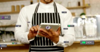 Kafe tezgahının arkasında tableti tıkırdatırken aynı zamanda sosyal medya pazarlama ölçülerini de gösteriyor. Kafe, dijital, modern, teknoloji, konukseverlik, iş akışı, moda