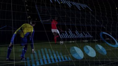 Kaleci ışıkların altında dalış topunu yakalıyor, analitik spor haberlerini izleyen saldırgan. Atletik, rekabet, taktik, strateji, performans, dijital, açık hava