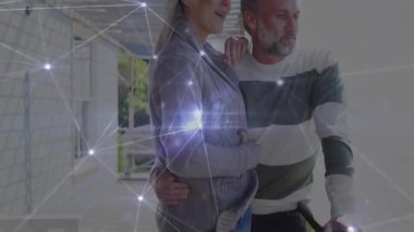 Olgun çift yenileme koridorunda duruyor. İnşaat için ışıldayan veri ağını gösteriyorlar. İnşaat, yenileme, veri, dijital, bağlantı, aile, işbirliği