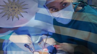 Ameliyathanede ameliyat yapan iki cerrah forseps neşter ve çizgili bayrak kaplaması gösteriyor. Tıbbi, sağlık, işletme, klinik, profesyonellik, hassasiyet, takım çalışması