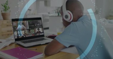 Genç öğrenci notlar yazıyor ve siber güvenlik grafikleriyle birlikte masadaki uzak sınıflara katılıyor. Eğitim, e-öğrenme, teknoloji, uzaktan, iletişim, yenilik, konsantrasyon