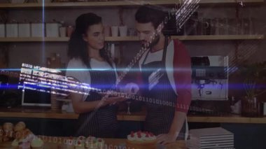 Tabletteki satış verilerini inceleyerek iki baristanın kahve işini arttırması ikili kaplamayı gösteriyor. Kafe, baristalar, dijital, yenilik, modern, takım çalışması, konukseverlik