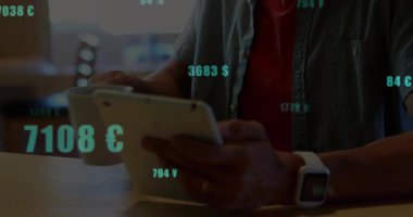 Tableti kontrol ederken elinde bardak tutan adam, finans verilerini vurgulayan yüzen para birimi sembollerini gösteriyor. Profesyonel, gündelik, modern, finansal, dijital, çalışma alanı,