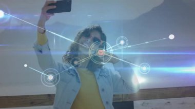 Suya tepeden bakan ahşap güvertede akıllı telefonu tutan kadın teknoloji ağı kaplamasını gösteriyor. Açık hava, yaşam tarzı, modern, manzaralı, bağlantı, boş zaman, canlı