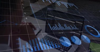 Veri analisti kadın masadan not alıyor, ekranı kaplayan finans tablolarını gösteren dizüstü bilgisayarlara bakıyor. Teknoloji, iş, analitik, dijital, profesyonel, modern, üretkenlik