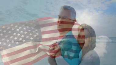 Yaşlı çift kumlu sahilde sırtında taşıyorlar ve seyahat reklamları için animasyon Amerikan bayrağı örtüyorlar. Son sınıf, plaj, arkadaşlık, macera, canlılık, açık hava, eğlence.