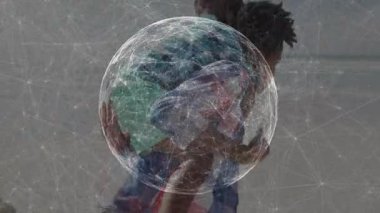 Kadın çocuğu sahilde tutuyor, bağlantı noktalarıyla teknoloji ağı küresi sergiliyor. Aile, bağlantı, teknoloji, ağ, açık hava, yenilik, fütüristik