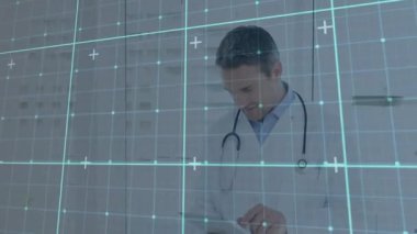 Erkek doktor tıbbi ofiste tableti inceliyor, holografik ızgara ve artı simgeler gösteriyor. Sağlık, teletıp, dijital sağlık, yenilik, profesyonellik, modern, teknoloji