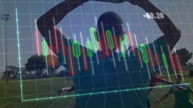 Erkek sporcu çimen tarlasında kollarını kaldırıyor, finans şebekesini şamdanlarla örtüyor. Sporcu, spor, yarışma, açık hava, güneş ışığı, takım çalışması, başarı