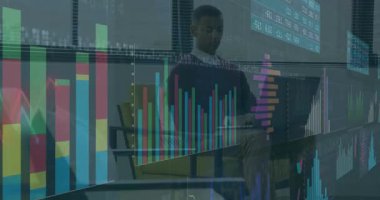 Modern ofis salonunda oturan erkek profesyonel, yüzen finansal haritalarla dizüstü bilgisayara bakıyor. Şirket, teknoloji, yenilik, çalışma alanı, üretkenlik, modern, analiz