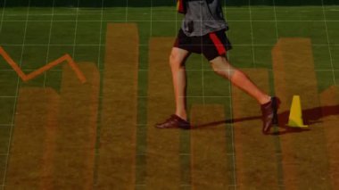 Erkek sporcu çimen sahasında futbol topunu tekmeliyor, spor analitik veri tablolarını gösteriyor. Atletik, zindelik, istatistik, performans, açık hava, zindelik, analiz