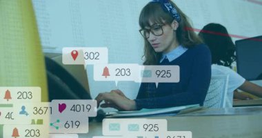 Ofiste yazan kadın pazarlamacı, veri örtülü dizüstü bilgisayarın etrafında yüzen sosyal medya simgeleri. Teknoloji, üretkenlik, işbirliği, yenilik, modern, çalışma alanı, dijital