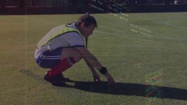 Kadın futbolcu sahada çömelmiş, yüzen çizgi grafikleriyle spor teknolojisi analitiği gösteriyor. Sporcu, fitness, inovasyon, dijital, açık hava, eğitim, modernizasyon