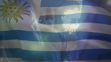 Cerrah ameliyathanede ameliyat yapıyor. Cerrahi ışık ve Uruguay bayrağı gösteriyor. Tıbbi, sağlık, kesinlik, yenilik, profesyonellik, steril, klinik