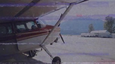 Hangar kapısını çeken adam, havacılık hangarındaki pervane uçağını animasyon uçuş verileriyle gösteriyor. Havacılık, uçak, hangar, ulaşım, macera, sanayi, açık hava