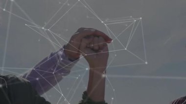 Ekip açık gökyüzü altında yumruklarını birleştiriyor, teknoloji için parlayan ağ çizgileri ve düğümlerini örtüyor. İşbirliği, birlik, takım çalışması, dijital, bağlantı, topluluk, yenilik