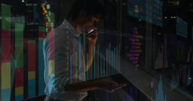 Akıllı telefondan konuşan ve gece ofisinde el kol hareketi yapan adam animasyon finans grafikleri gösteriyor. İş, finans, teknoloji, analitik, şirket, veri görselleştirme, modern