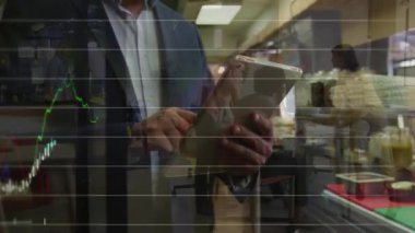 Elinde tablet olan bir adam, animasyon finans grafikleri ve şamdan çizelgeleri havada süzülüyor. Teknoloji, işbirliği, veri, iletişim, modern, kurumsal, üretkenlik