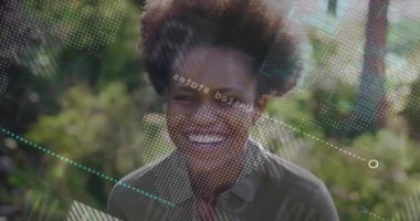 Sunlit Park 'ta gülümseyen bir kadın noktalı dünya haritası ve turkuaz yapay zeka şekilleriyle teknoloji örtüsü sergiliyor. Teknoloji, yenilik, bağlantı, açık hava, canlılık, modern, boş zaman