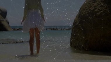 Kayalık sahildeki sığ sularda çıplak ayakla ayakta duran bir kız. Animasyon sağlık çizelgeleri sergiliyor. Doğa, deniz kenarı, sükunet, masumiyet, açık hava, manzara, minimalist