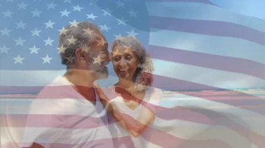 Deniz kıyısında kucaklaşan kıdemli çift, şeffaf bayrak kaplamalı sağlık markaları sergiliyorlar. Romantizm, şefkat, sükunet, açık hava, sükunet, bağlantı, uyum.