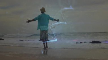 Sahildeki sığ suda çıplak ayakla duran hasır şapkalı bir adam teknoloji pazarlama hologramlarını gösteriyor. Yalnızlık, dinginlik, fütüristik, dijital, yenilik, rahatlık, rahatlama.