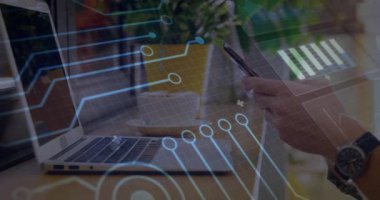 Ofis çalışanı ahşap masada akıllı telefonu tutuyor, dizüstü bilgisayar ve bitki üzerindeki teknoloji devrelerini gösteriyor. Teknoloji, yenilik, çalışma alanı, dijital, bağlantı, modern, üretkenlik