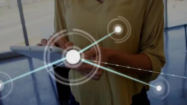 Kadın tableti modern ofis içinde tıklatıyor, teknoloji ağı düğümlerini ve veri görsellemesini gösteriyor. Teknoloji, yenilik, işbirliği, dijital, işyeri, modern, bağlantı