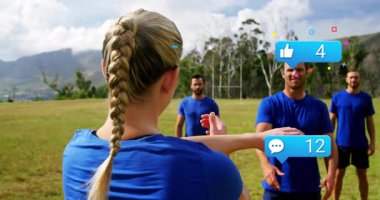 Çimenli alanda spor salonunu yöneten kadın eğitmen, yüzen sosyal medya simgelerini gösteriyor. Spor, açık hava, takım çalışması, motivasyon, enerji, sağlık, egzersiz