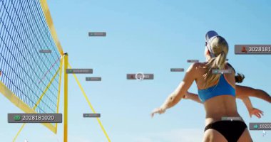 Plaj voleybol sahasında atlayan bayan sporcular spor analitiği için yüzen veri etiketlerini gösteriyorlar. Atletizm, rekabet, spor, hareket, enerji, açık hava, canlı