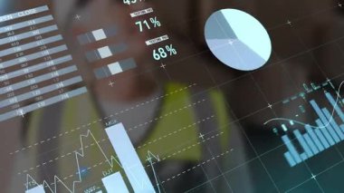 Güvenli yelek giyen olgun bir adam harita turtası, bar ve şamdan çizelgeleri gösteren bir arayüz kullanıyor. Analizler, teknoloji, yenilik, gösterge paneli, sanayi, veri, yönetim