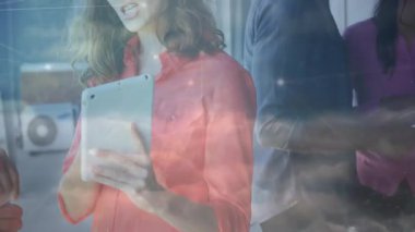 Çalışma alanında tablet etrafında iş birliği yapan iş arkadaşları, teknoloji ağını keşfederek görselleri örtüyor. İşbirliği, takım çalışması, modern, teknoloji, ağ oluşturma, profesyonel, iletişim