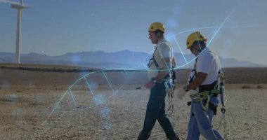 Rüzgar çiftliğinde türbin yakınında yürüyen iki teknisyen enerji için çift sarmallı grafikler çiziyorlar. Yenilenebilir enerji, endüstri, teknoloji, takım çalışması, açık hava, mühendislik