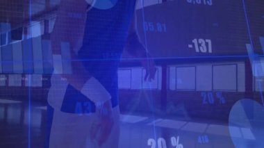 Spor salonunda basketbol tutan erkek sporcu animasyon mavi çizelgeler ve metrik çizelgeler sergiliyor. Sporcu, spor, spor, analitik, görselleştirme, eğitim, yarışma