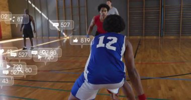 Erkekler basketbol oynuyorlar ve spor salonunda savunma yapıyorlar. Pazarlama için sosyal medya ikonları örtüyorlar. Atletizm, takım çalışması, rekabet, şehir, enerjik, spor kıyafeti, fitness