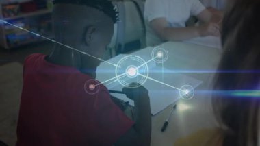 Sınıf arkadaşları kağıt üzerinde kalemle yazarken ağ düğümleri teknoloji grafikleri üzerinden bağlanıyor. Çocuklar, eğitim, bağlantı, öğrenme, işbirliği, teknoloji, sınıf