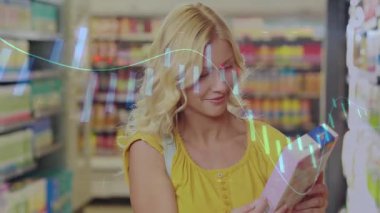 Kadın, raflarda bar çizelgelerini gösteren perakende analizleriyle parlak market koridorlarına göz atıyor. Perakende, ticaret, pazarlama, veri görselleştirme, tüketici, teknoloji, kentleşme