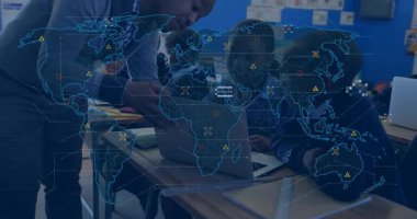 Öğretmen, öğrencilere, eğitim için haritaları haritayla eşleştiren dizüstü bilgisayarlar kullanarak rehberlik ediyor. Eğitim, akıl hocalığı, işbirliği, dijital öğrenme, sınıf, teknoloji, eğitim