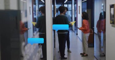 Ofis koridorunda elinde tablet ve telefonla konuşan üç iş arkadaşı yüzen sohbet baloncukları gösteriyor. İşbirliği, profesyonellik, iletişim, modernlik, işyeri, takım çalışması, yenilik