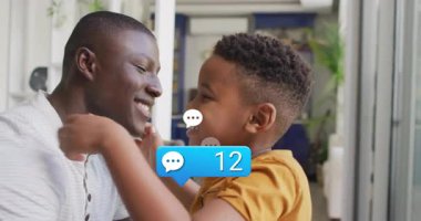 Ebeveyn ve çocuk oturma odasında kucaklaşıyorlar, yüzen teknoloji sohbet baloncukları ve 47 bilgilendirme ile. Aile, bağlantı, sıcaklık, iletişim, dijital, ev, mutluluk